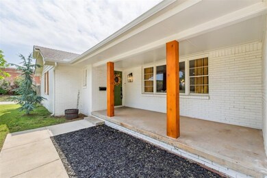 Doorway to property featuring covered porch and brick siding