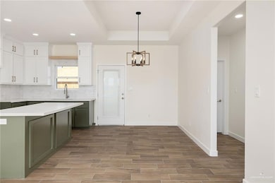 Kitchen with green cabinetry, recessed lighting, white cabinetry, and wood finish floors
