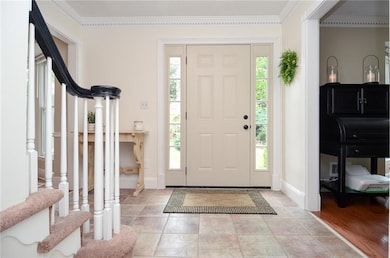 Entrance foyer with baseboards, ornamental molding