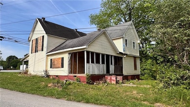 View of front facade with crawl space, a shingled roof, and a front yard
