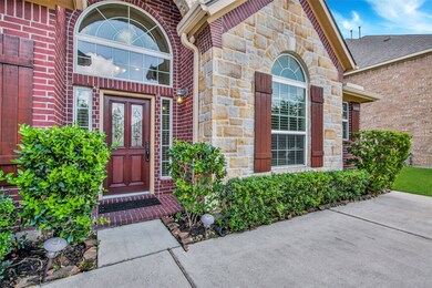The front walk is beautifully landscaped and accented by a mahogany leaded glass front door.