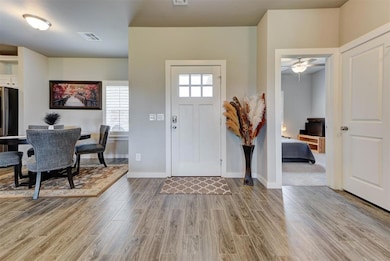 Foyer featuring wood finished floors, a ceiling fan, and baseboards
