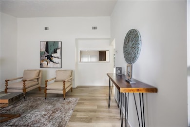 Living area featuring light wood-type flooring and baseboards