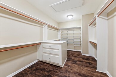 HUGE walk-in closet with a dual sided built-in dresser.