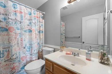 Bathroom featuring vanity, wainscoting, and a shower with curtain