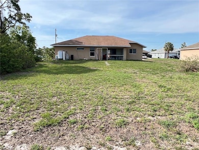 Rear view of house with its sunroom and backyard