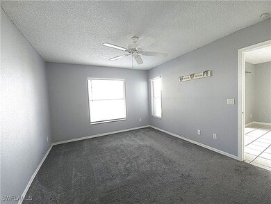Spare room with dark colored carpet, baseboards, a