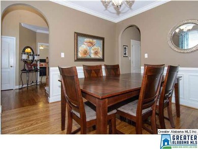 Formal dining room with hardwoods, crown and arche