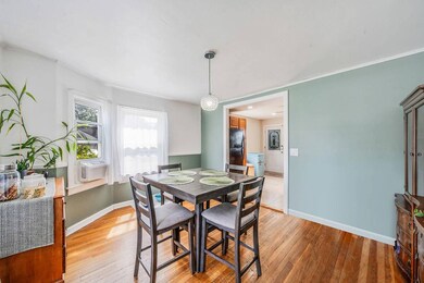 Dining space with light wood-type flooring, ornamental molding, and cooling unit