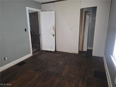 Spare room featuring dark wood finished floors