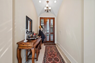 Formal entry with glass door and marble floors.