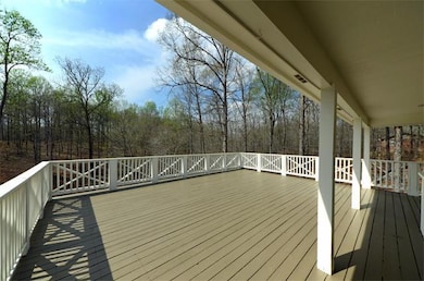 Huge party deck has two levels overlooking 5 wooded acres with picturesque creek.
