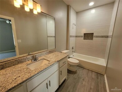 Full bath with toilet, wood finished floors, ceiling fan, vanity, and shower / tub combination