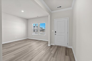 Foyer featuring wood finished floors, crown moldin