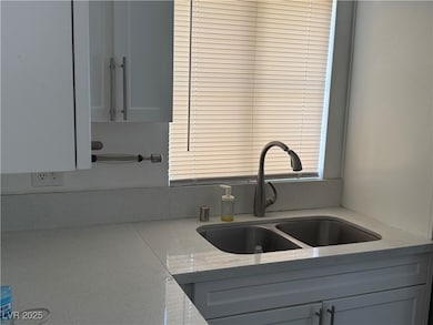 Kitchen view of a sink and light stone countertops