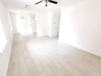 Unfurnished room featuring a ceiling fan, light wood-style flooring, and baseboards