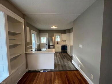 Kitchen featuring backsplash, light countertops, stainless steel appliances, and dark hardwood floors