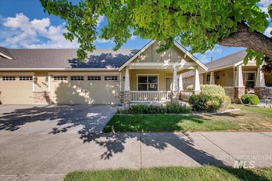 Craftsman inspired home featuring covered porch, an attached garage, driveway, and stone siding
