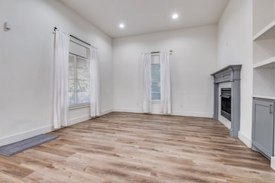 Unfurnished living room featuring a fireplace, light wood-type flooring, and recessed lighting