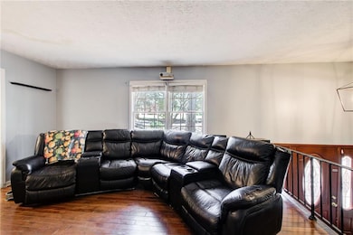 Living area with a textured ceiling and hardwood /