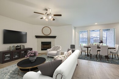 Living room with a tile fireplace, ceiling fan, an