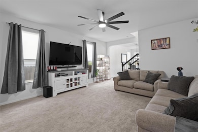 Living area with light carpet, arched walkways, h