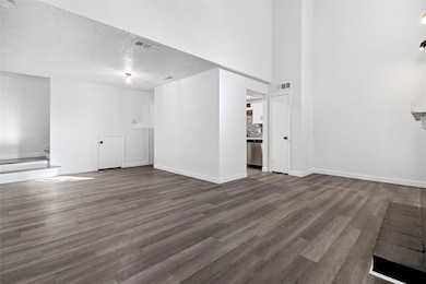 Unfurnished living room with dark wood-type floori