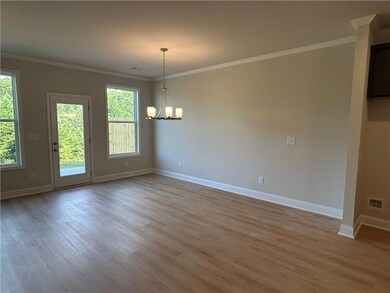 Spare room featuring wood finished floors, a chandelier, and crown molding