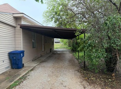 View of side of home featuring dirt driveway and a