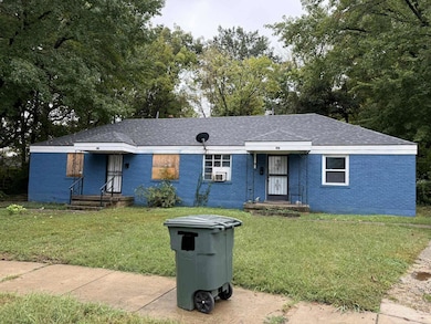 Ranch-style home with a front lawn, brick siding, a shingled roof, and view of scattered trees