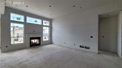 Great Room with engineered wood flooring, LED lighting, plenty of natural light through the large windows, and a 2-sided fireplace! Please, excuse our dust as this home is currently under construction.