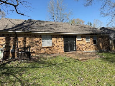 Back of house with roof with shingles, brick sidin