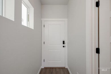 Doorway featuring baseboards and wood finished floors