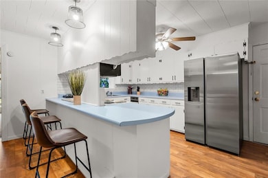 Kitchen with stainless steel fridge, white cabinet