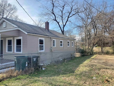 View of property exterior with a chimney, roof wit