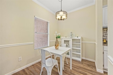 Dining room with baseboards, crown molding, a cha