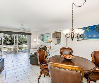 Dining space with light tile patterned floors, a chandelier, and a ceiling fan