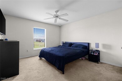 Bedroom with light colored carpet, baseboards, and