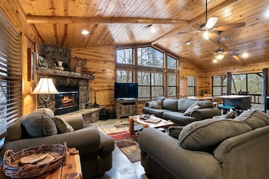 Living room with beam ceiling, wooden walls, a sto