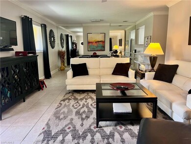 Living area featuring ornamental molding and light tile patterned floors