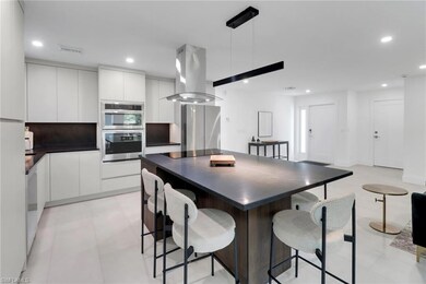 Kitchen with island exhaust hood, dark countertops