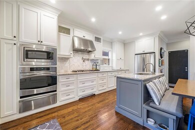 Kitchen with white cabinetry, wall oven, built-in 
