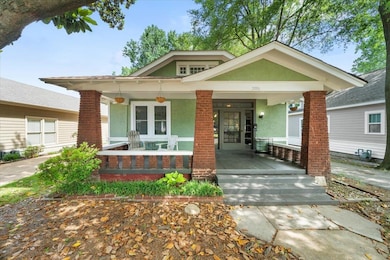 View of front facade with covered porch and stucco siding