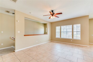 Unfurnished room with ceiling fan and light tile p