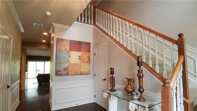 Beautiful entry with hardwood flooring, crown mold