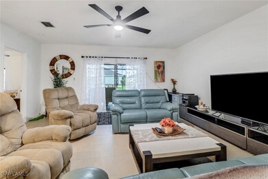 Living room featuring ceiling fan and light tile p