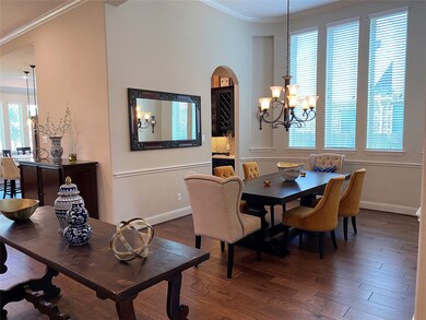 Dining room with crown molding and butlers pantry with built in cabinets & wine rack