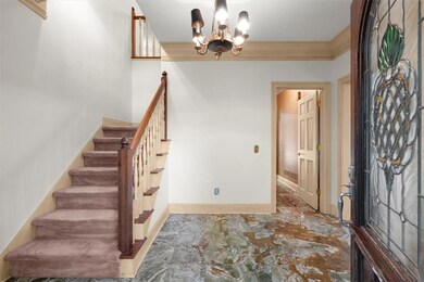 Foyer entrance featuring a chandelier and ornamental molding