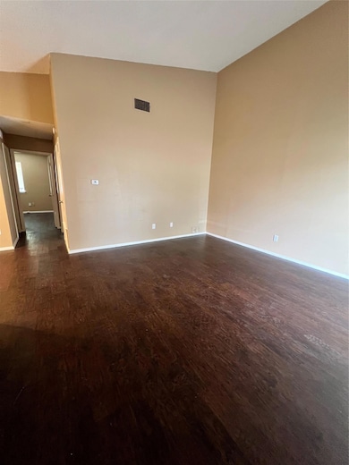 Empty room with dark wood-style floors and basebo