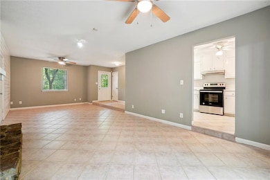Unfurnished living room featuring light tile patterned flooring and ceiling fan